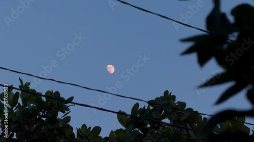 Luna brillante entre el cableado de la ciudad 