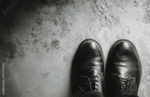 Polished Black Shoes on a Textured Concrete Surface in a Low-Light Setting