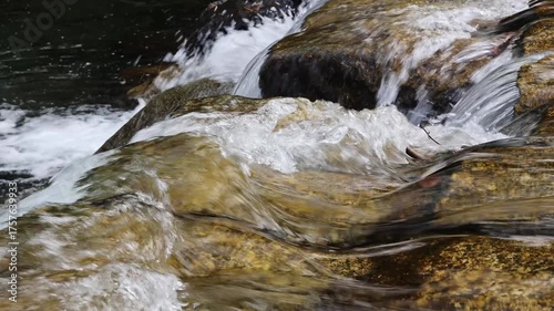 Rushing Water Flowing Over Rocky River Bed in Golden Sunlight, 4k resolution