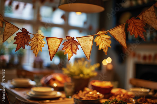 Close-up of fall leaf garland over a blurred Thanksgiving dinner table with warm lights and bokeh. Ideal for banners, ads,, seasonal design, festive home decor concepts. holiday meal