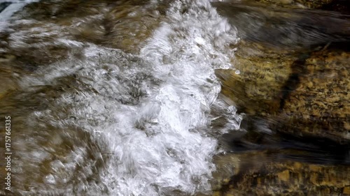 Crystal Clear Stream Water Flowing Over Rocky Riverbed in Natural Environment