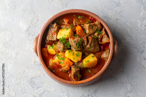 Beef goulash, soup and a stew, made of beef chuck steak, potatoes and plenty of paprika. Hungarian  traditional meal.