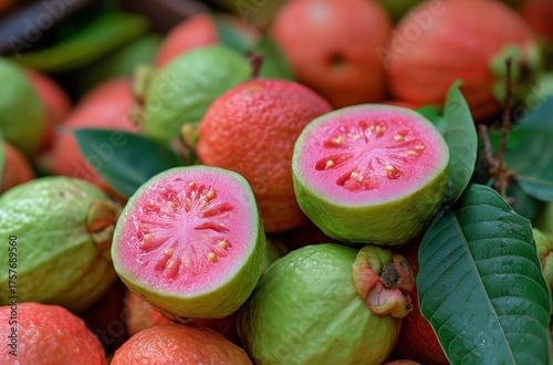 Fresh Guavas Piled Together With Sliced Guava Revealing Vibrant Pink Flesh an...