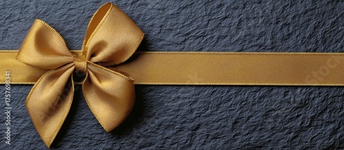 Elegant Golden Ribbon Bow on Dark Textured Background for Special Occasions a...