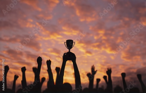 Celebrating Victory Under a Vibrant Sunset With Raised Hands Holding a Trophy