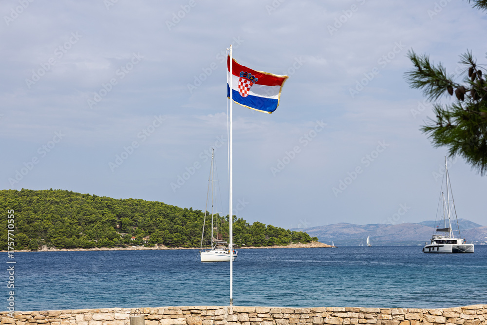 Fototapeta premium Croatian Flag Over Seaside With Boats At Sunny Coastal Scene