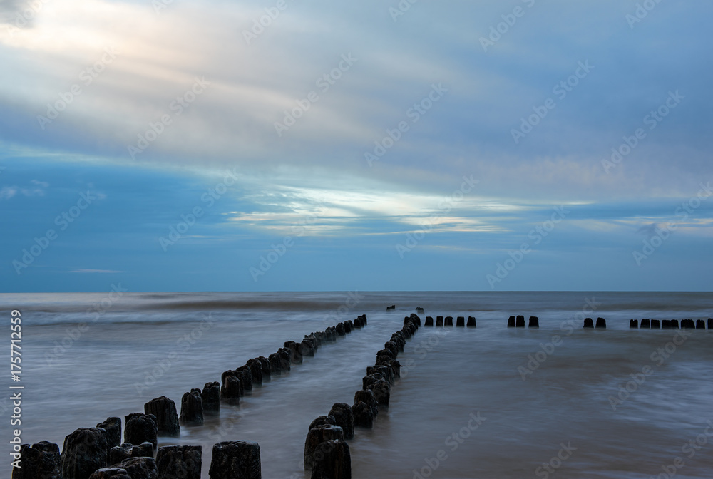 Fototapeta premium the sea during the blue hour, posts, pilings