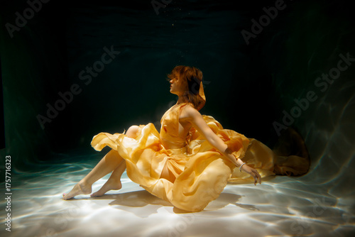 An Enchanting Underwater Dance Performance Taking Place in a Beautiful Yellow Dress