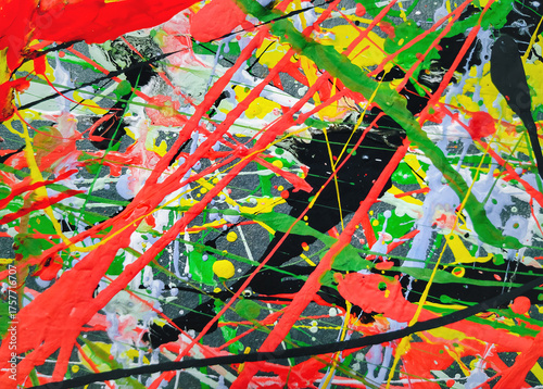 Abstract grunge background made of acrylic latex paint. Green, red, yellow and black spots of flowing splattered paint. Abstract expressionism. Action painting.