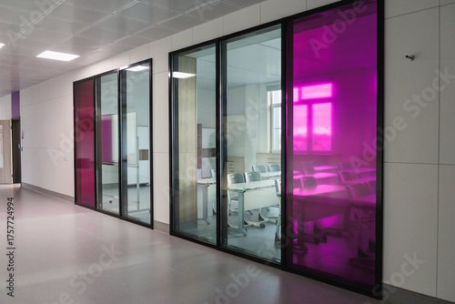 Modern Office Corridor with Glass Meeting Rooms and Pink Accents