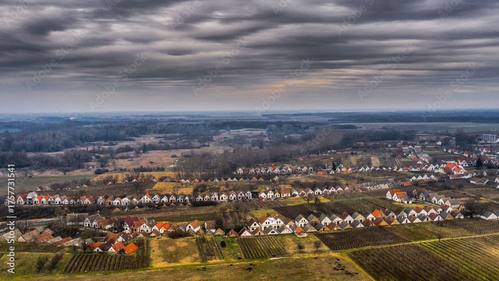 Fototapeta premium Aerial view of a wine village in winter light Traditional wine cellars line the hills of a Hungarian village under dramatic winte