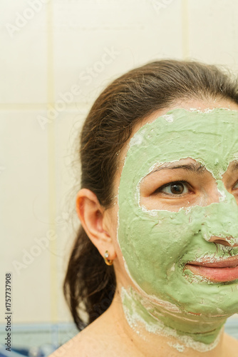 Woman Relaxing With Green Clay Face Mask in Bathroom