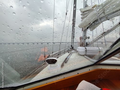 Rain-Splashed Window View from Yacht Cabin towards Distant Bridge.