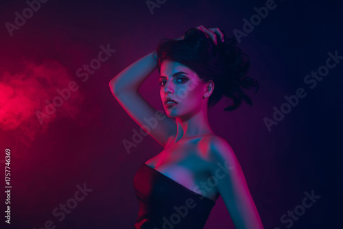 Passionate glamorous woman in neon lighting with smoke, showcasing modern elegant style and beauty.