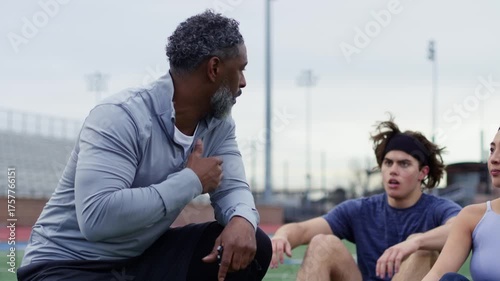 Coach provides guidance and motivation to athletes during an outdoor training session.