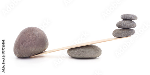 Balance concept with stacked stones on wooden plank isolated on white.