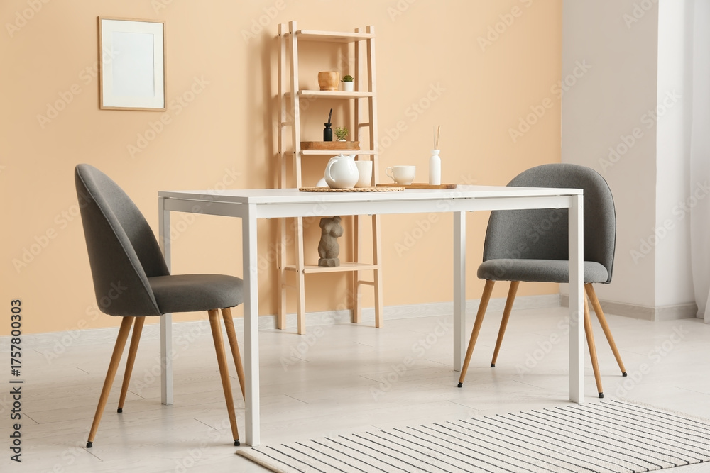 Fototapeta premium Interior of dining room with table and chairs near beige wall