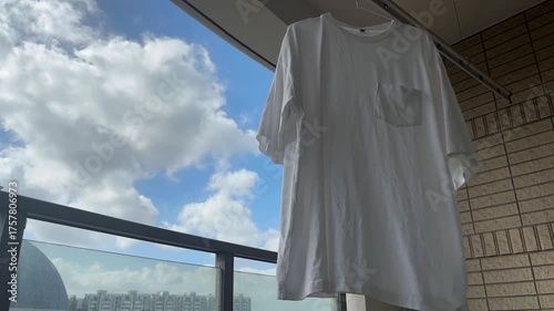 白いTシャツが青空の下で風に揺れる穏やかな午後の暮らし