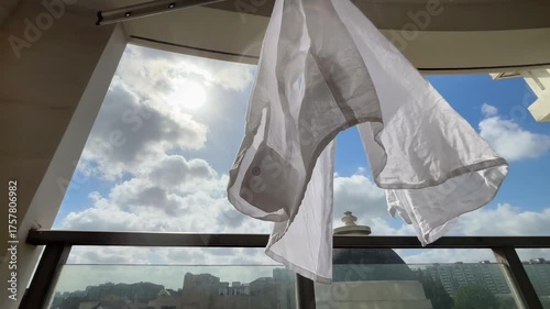 青空と太陽の光に透ける白いシャツが風に揺れる午後
