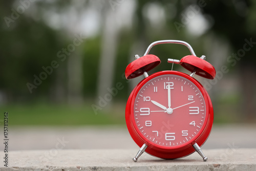 Red alarm clock on pavement...