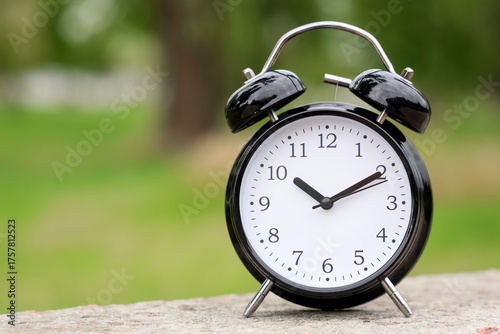 Black alarm clock on paveme...