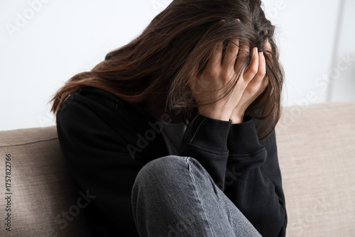 Sad young woman sitting on ...