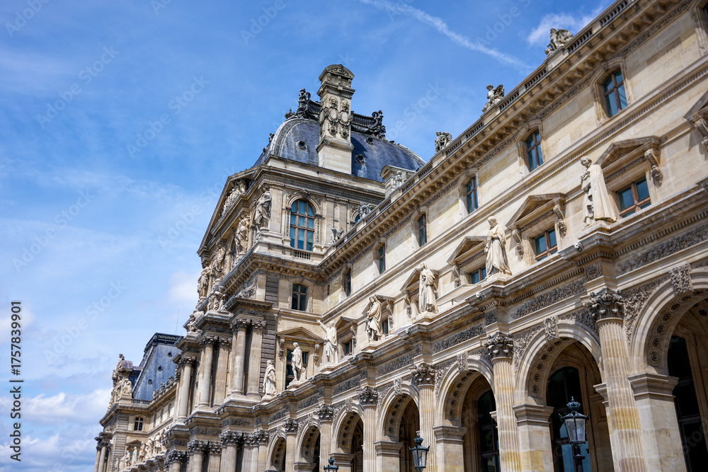 Fototapeta premium Historic Louvre building with detailed architecture and blue sky editorial use only