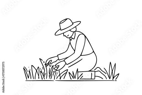 Woman is kneeling in a field and pulling weeds. She is wearing a hat and a shirt