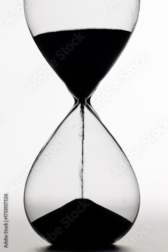 Obraz na plátne Classic glass hourglass with dark sand captures concepts of impermanence, countdown, patience, and passage of life