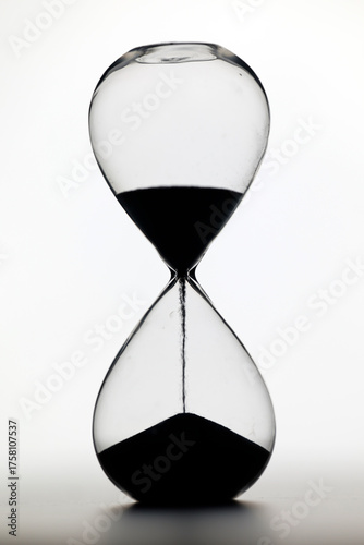 Canvas Print Classic glass hourglass with dark sand captures concepts of impermanence, countdown, patience, and passage of life