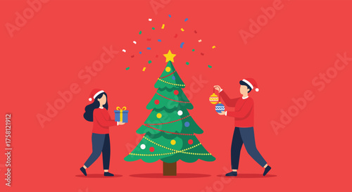 Two people in santa hats decorate a christmas tree with presents and confetti.
