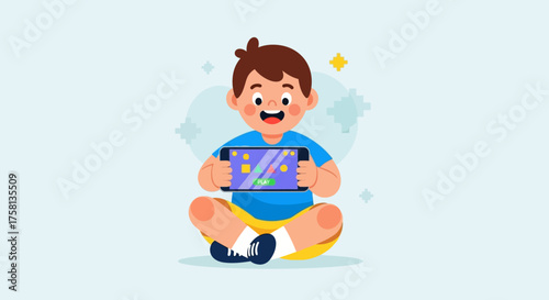 A happy young boy sitting cross-legged and playing a video game on a handheld console.