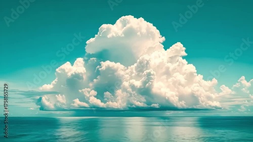 A large cloud over a body of water under a blue sky