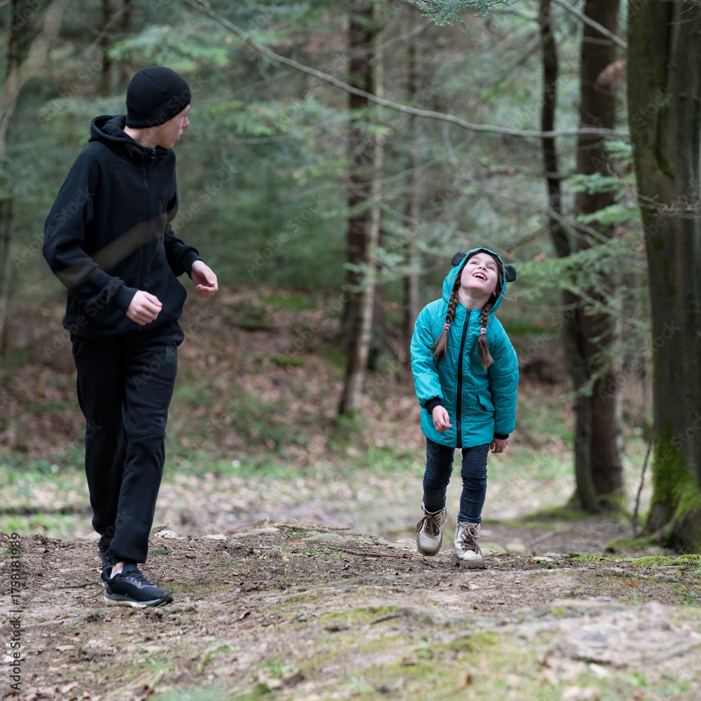 Fototapeta premium Joyful moments of a father and daughter exploring a serene forest trail on a crisp autumn day while enjoying nature's beauty together in peaceful harmony