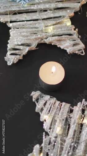 Animation of christmas decorations and tea candles over snowflakes on grey background