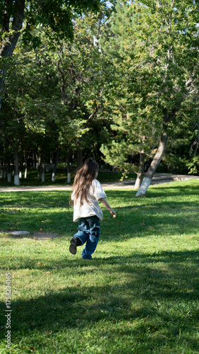 A 9-year-old girl runs in the park in summer. High quality photo