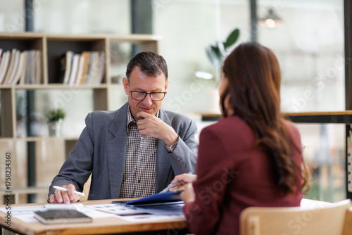 Mature man discussing business documents with colleague