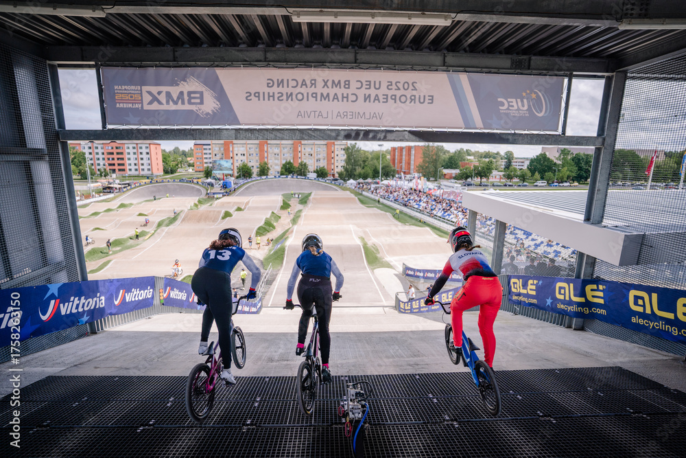 Fototapeta premium Valmiera, Latvia - July 12, 2025: BMX racers preparing to start at 2023 UEC BMX Racing European Championships event. BMX European championships