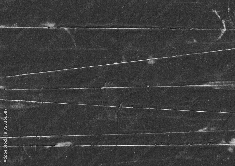 Fototapeta premium Black paper with fold line grunge background. Abstract rough surface backdrop. Distressed monochrome graphic element. For creative overlay design.