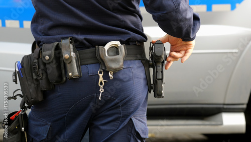 Photos Police officer in a uniform with his hand on holstered pistol, duty belt carryin