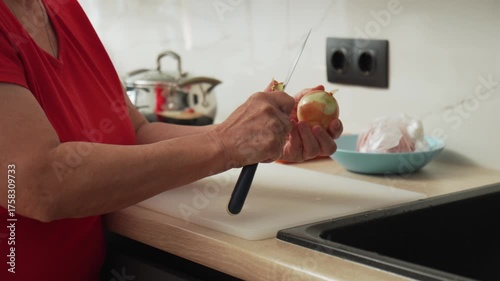 Preparing onions for cooking in a bright kitchen during a busy day