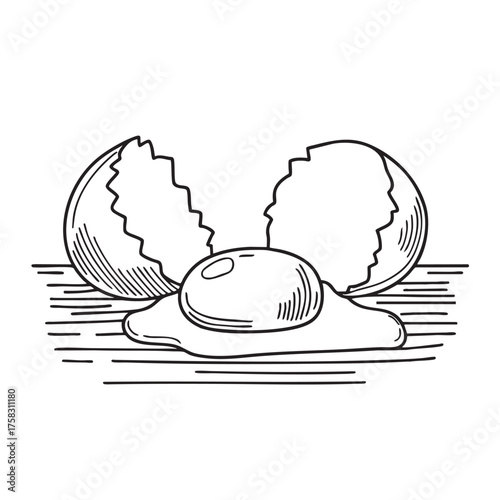 A yolk beside a cracked eggshell on a wooden surface