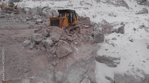 A tractor moves rock in a quarry.