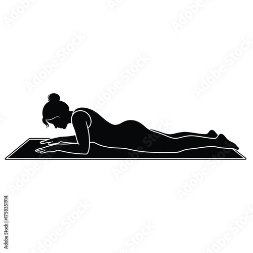 Silhouette of a woman in yoga position lying on her stomach on a mat with her elbows down flat