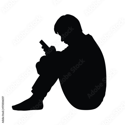 Silhouette of a person sitting with legs crossed holding a phone looking down at the screen intently