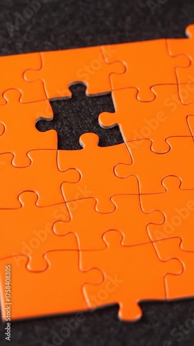 Orange puzzle with missing piece on dark background for conceptual design