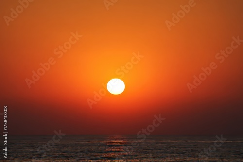 Vibrant Sunset Over Ocean Horizon Displaying Warm Orange and Red Hues with Reflection in Water