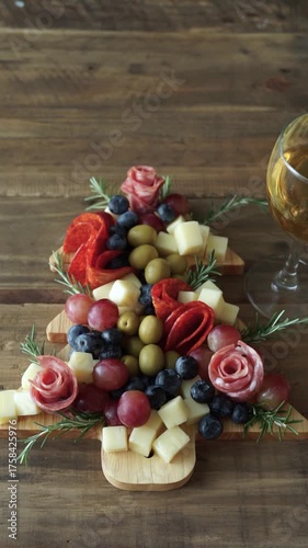 Charcuterie board for parties shaped like a Christmas tree with a glass of wine.