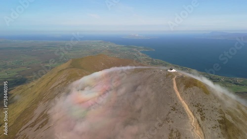 Amazing 4K aerial video of flying above and around Most Famous mountain in Ireland - Croagh Patrick in windy weather, with moving fog and clouds with breathtaking views around, Westport, Ireland