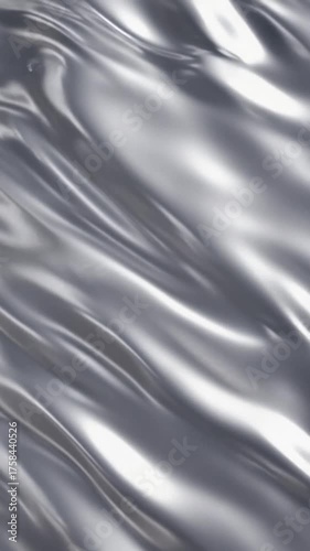 Abstract rippled silver metal surface for background textures and modern designs. Smooth flowing metallic wave pattern with reflective surface.